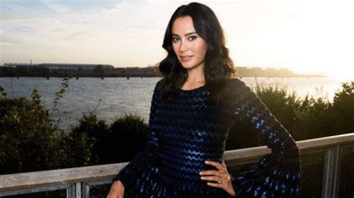 Emma Heming Willis is posing for a picture in a blue sparkly dress.